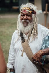 Wiruungga Dunggiirr, aboriginec v bílém obelčení a s bílými dredy a barevným šátkem